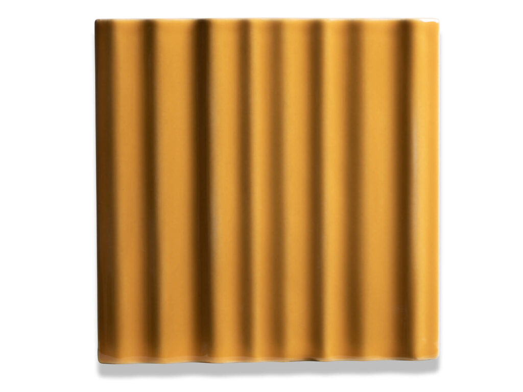 Fliese BASIL in der Farbe Amber. Das Bild zeigt eine einzelne BASIL-Fliese in einem orange-gelben Farbton. Die Datei ist ein Foto im JPEG-Format.
