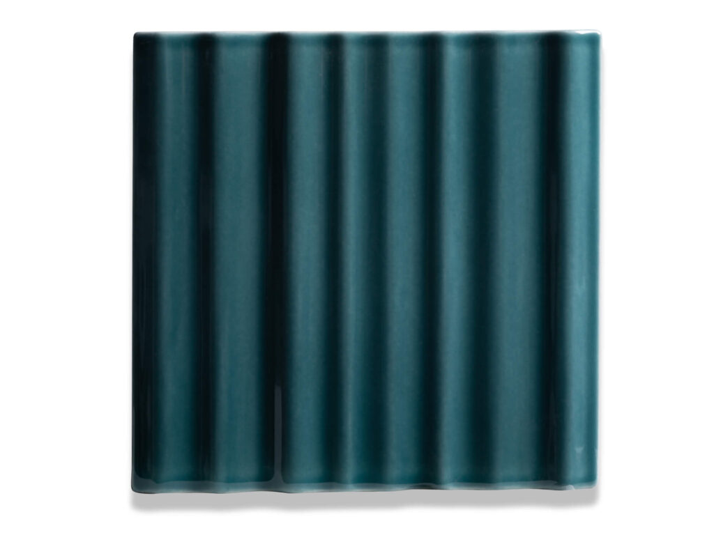 Fliese BASIL in der Farbe Petrol. Das Bild zeigt eine einzelne BASIL-Fliese in einem tuerkis-blauen Farbton. Die Datei ist ein Foto im JPEG-Format.