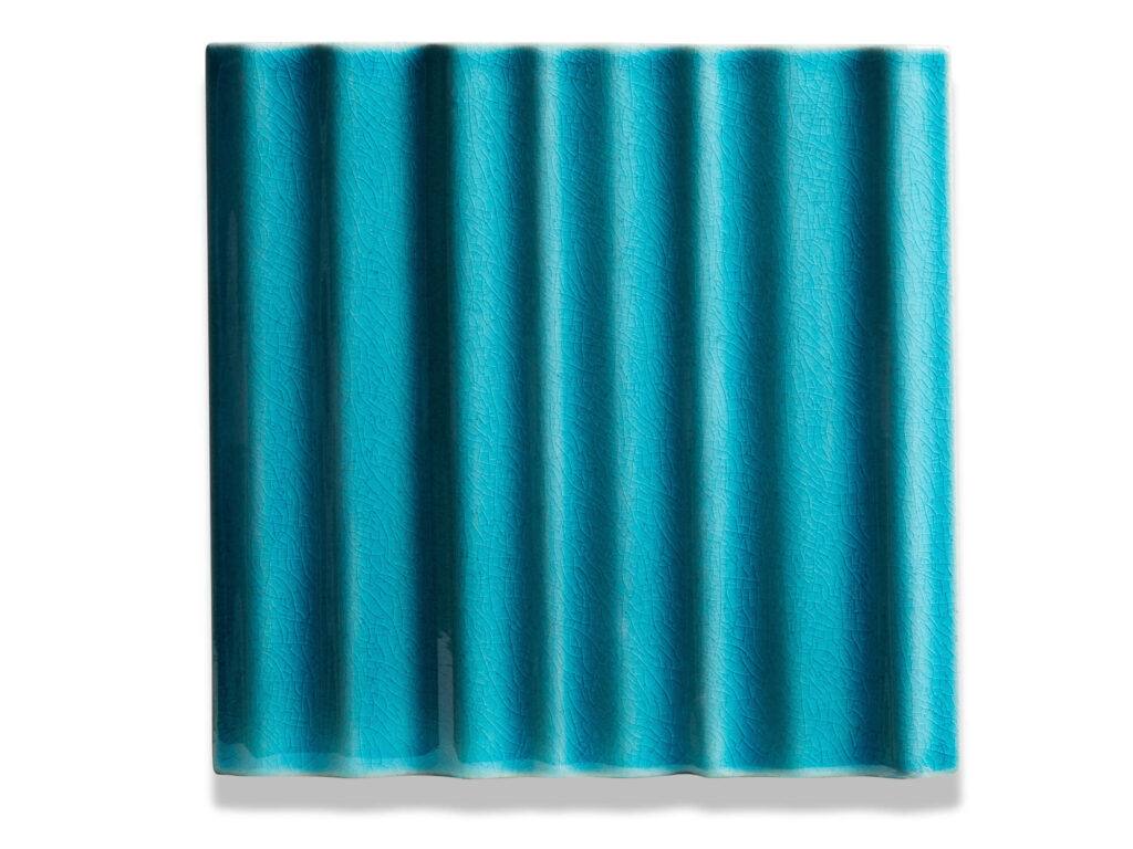 Fliese BASIL in der Farbe Turquoise crauele. Das Bild zeigt eine einzelne BASIL-Fliese in einem tuerkisen Farbton mit Craquele-Effekt. Die Datei ist ein Foto im JPEG-Format.