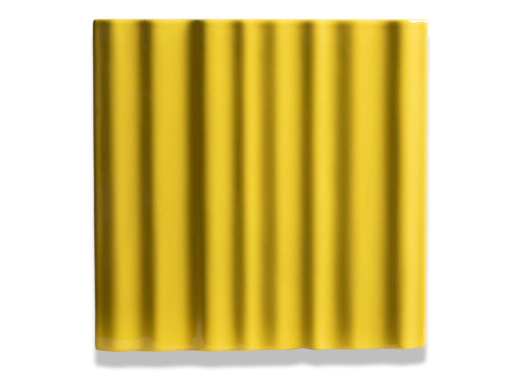 Fliese BASIL in der Farbe Yellow. Das Bild zeigt eine einzelne BASIL-Fliese in einem gelben Farbton. Die Datei ist ein Foto im JPEG-Format.