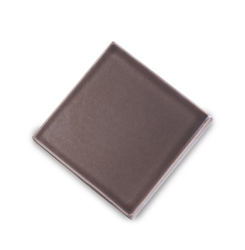 Fliese PLAETTLI in der Farbe Mocca. Das Bild zeigt eine einzelne PLAETTLI-Fliese in einem braunen Farbton. Die Datei ist ein Foto im JPEG-Format.