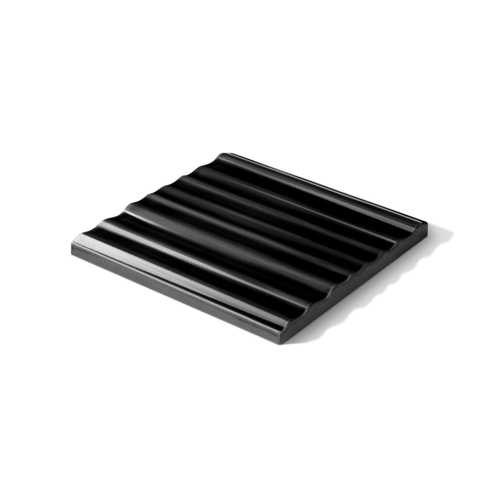 Fliese BASIL liegend in der Farbe Schwarz. Das Bild zeigt eine einzelne, liegende BASIL-Fliese in einem schwarzen Farbton. Die Datei ist ein Foto im JPEG-Format.