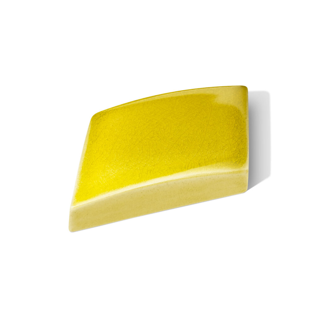Fliese LIMMAT in der Farbe Gelb Craquelé. Das Bild zeigt eine einzelne LIMMAT-Fliese in einem gelben Farbton. Die Datei ist ein Foto im JPEG-Format.