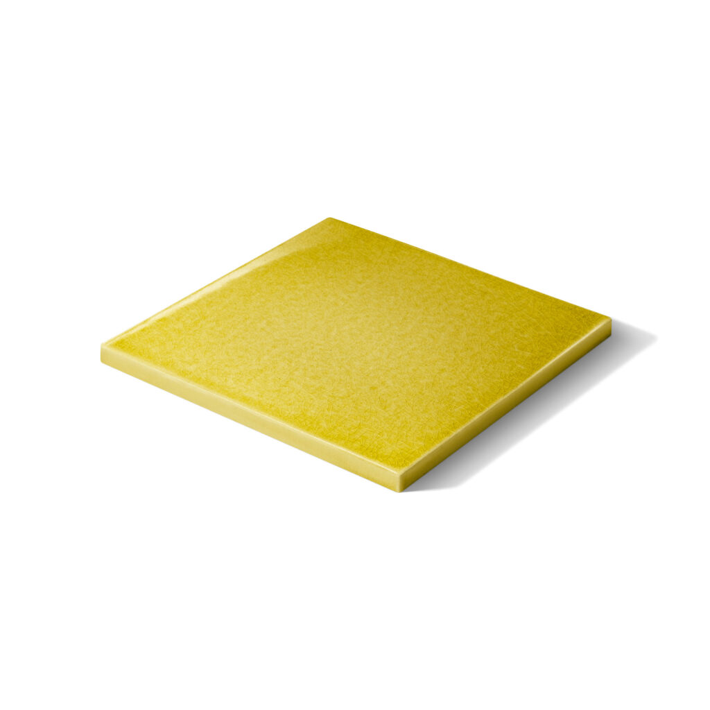 Fliese LONDRA in der Farbe Gelb Craquelé. Das Bild zeigt eine einzelne LONDRA-Fliese in einem gelben Farbton. Die Fliese sieht man in der Perspektive. Die Datei ist ein Foto im JPEG-Format.