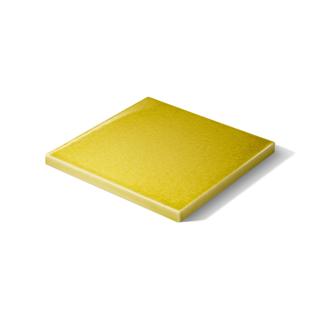 Fliese PLANO liegend in der Farbe Gelb Craquelé. Das Bild zeigt eine einzelne, liegende PLANO-Fliese in einem gelben Farbton. Die Datei ist ein Foto im JPEG-Format.